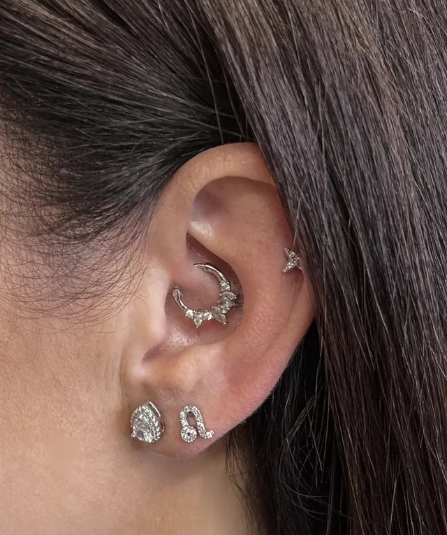 Ausis su daith, tragus ir spenelio vėrimais, papuošta žėrinčiais auskarais